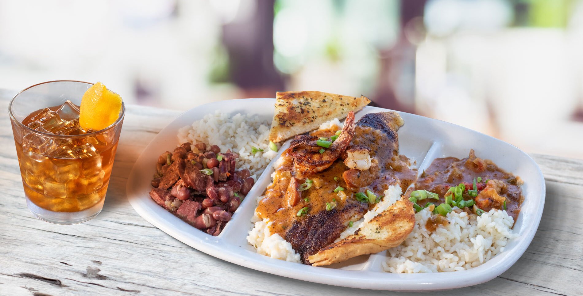 Blackened catfish topped with 2 large blackened shrimp, with jalapeno cheese grits smothered in andouille sausage gravy, plus our homemade crawfish etouffee and red beans and rice