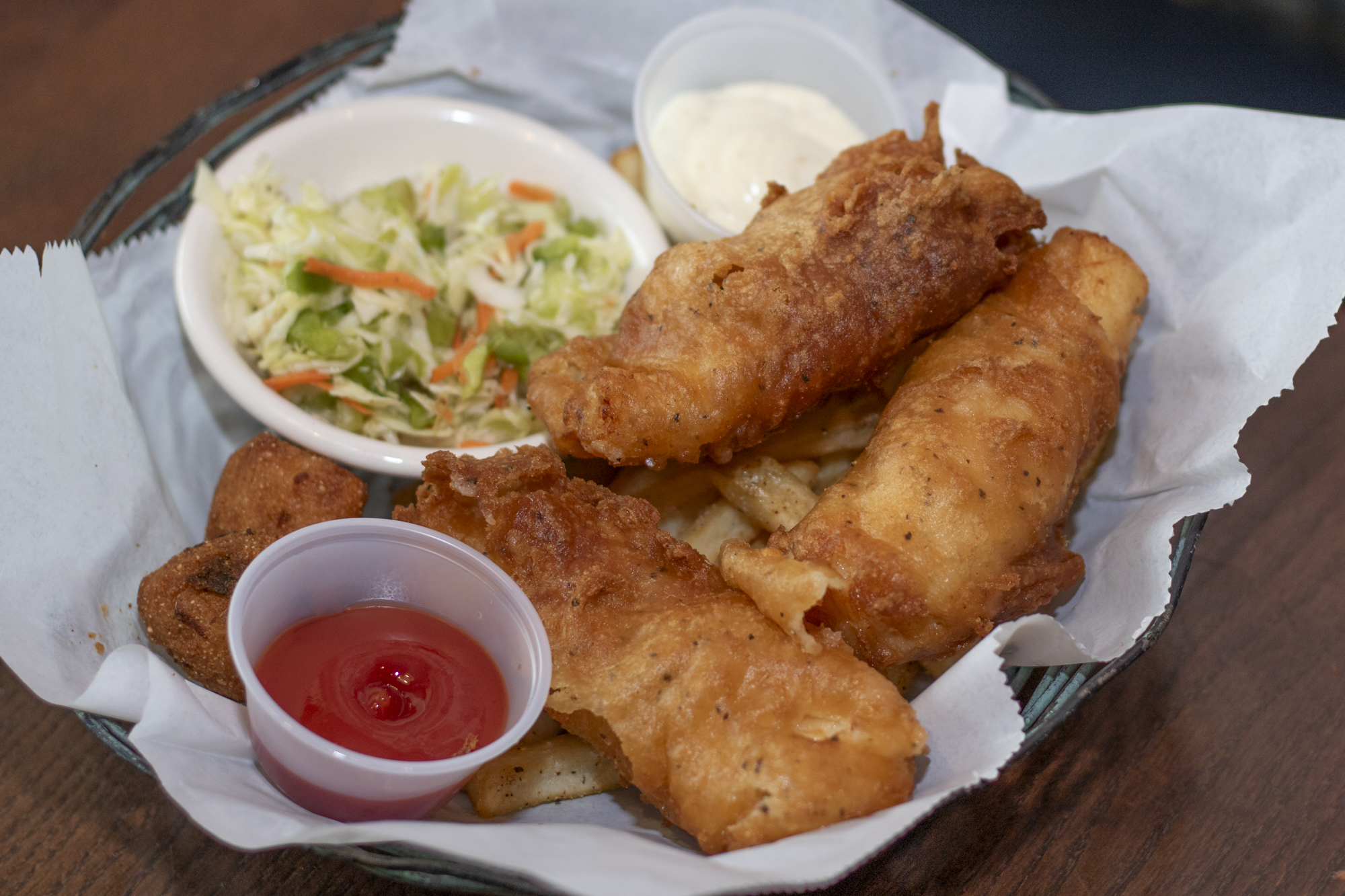 Alaskan cod hand battered in our beer batter and deep fried. Served with crispy french fries, apple cider slaw, and our jalapeno hush puppies