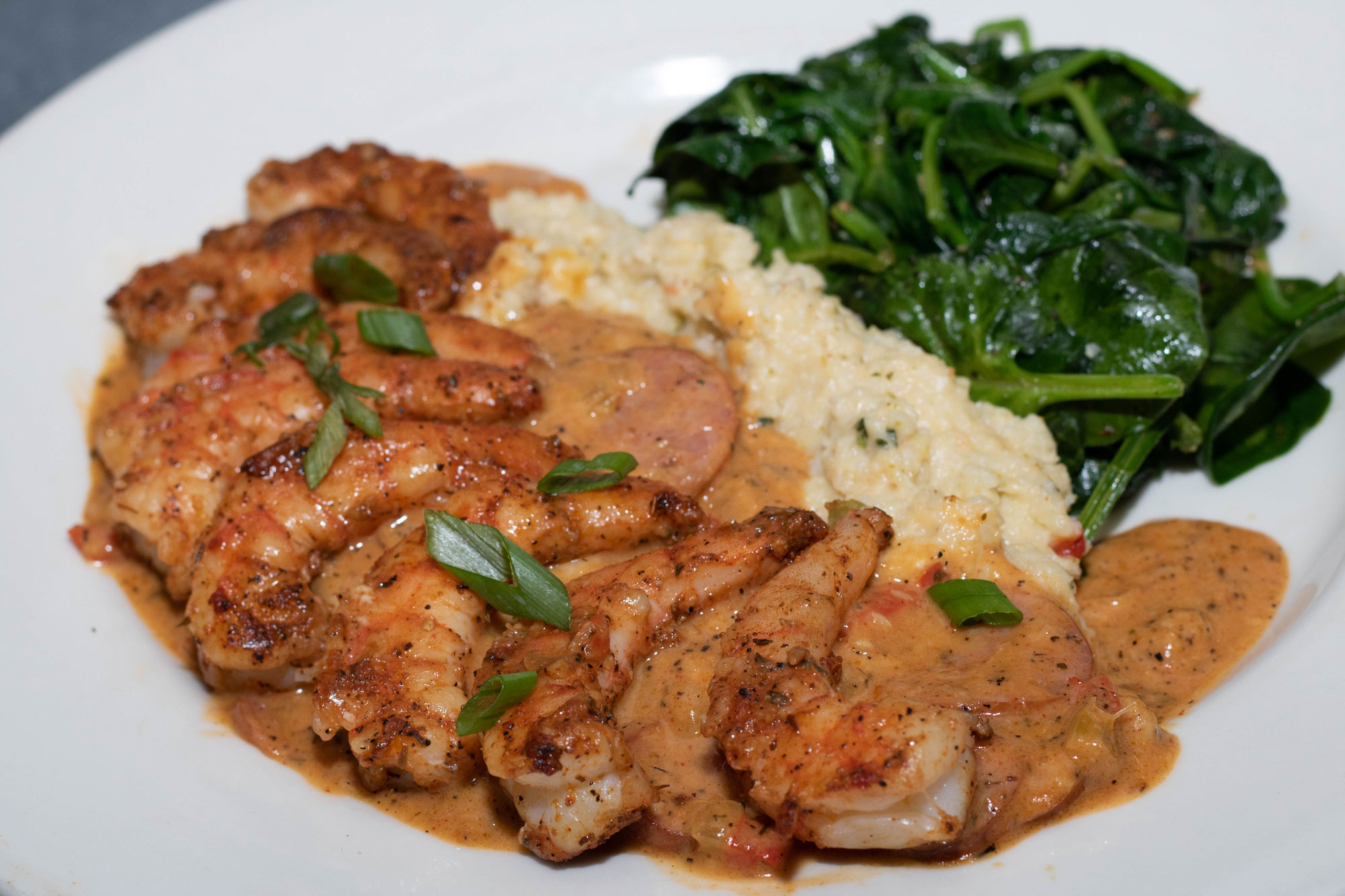 Large blackened shrimp atop jalapeno cheese grits with andouille sausage gravy and a side of sauteed spinach