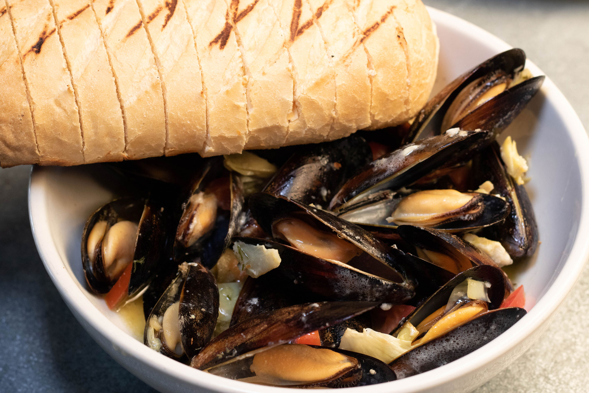 1 lb of Chilean mussels sautéed in white wine garlic butter, with tomatoes, artichokes, and toasted bread 