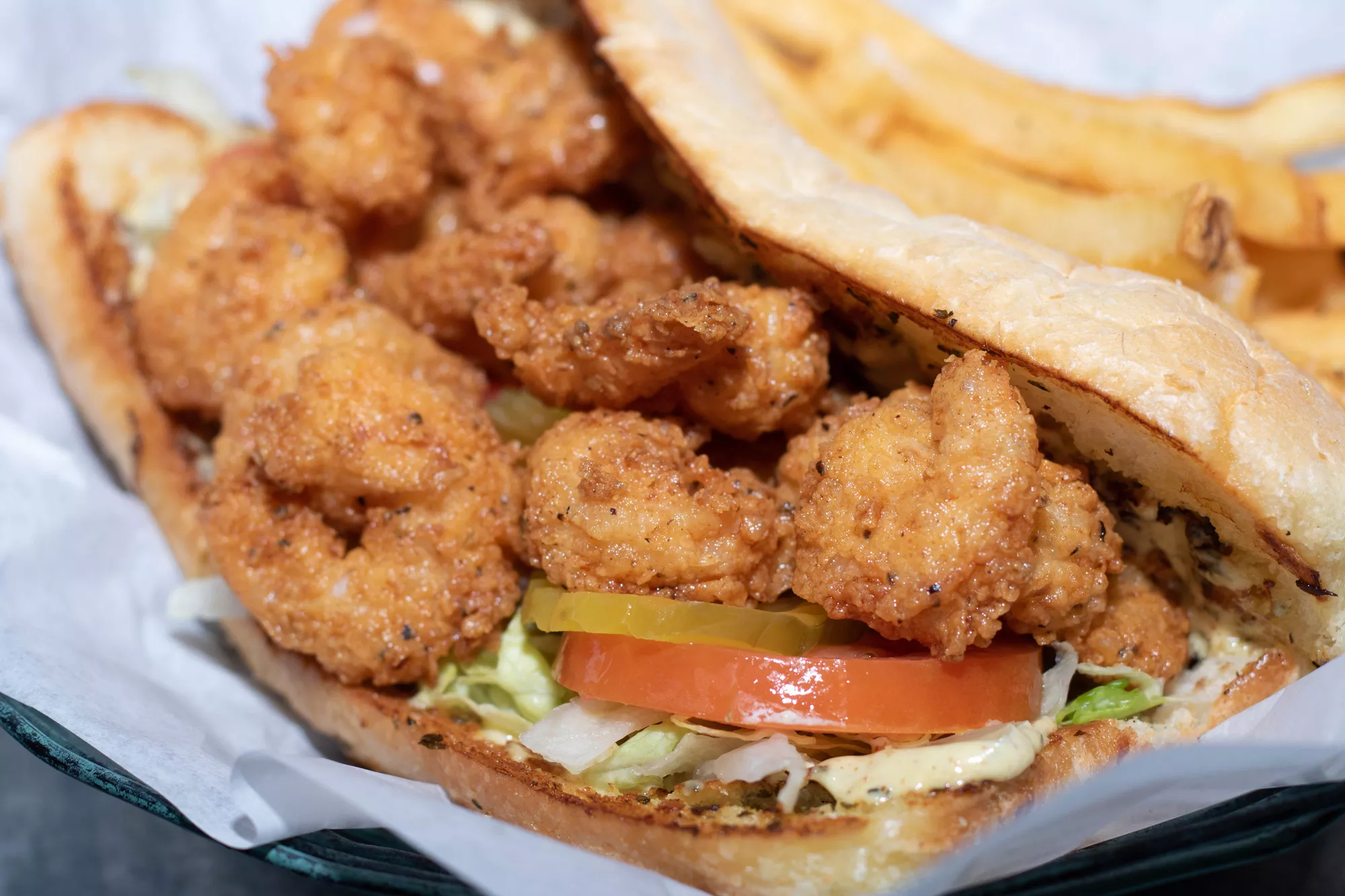 Loaded with baby shrimp tossed in our seasoned flour atop toasted French bread with lettuce, tomatoes, pickles, and creole mustard, served with a side of crispy fries