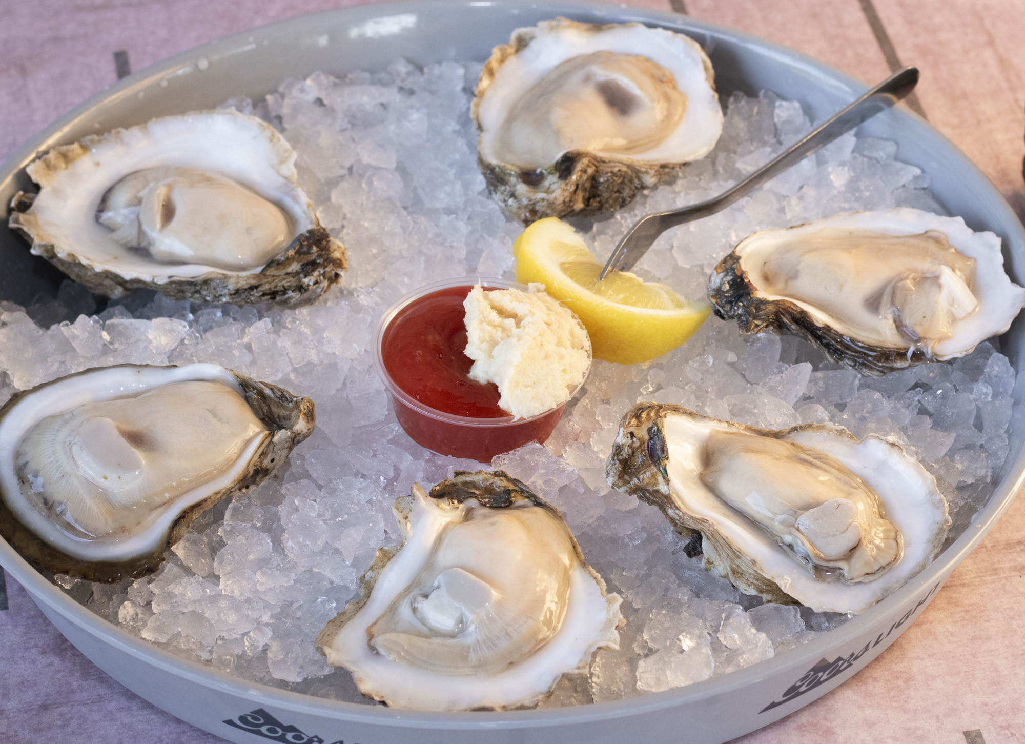 Freshly shucked Ameripure Gulf oysters served with homemade cocktail sauce, lemon wedges, a dollop of horseradish, and crackers.