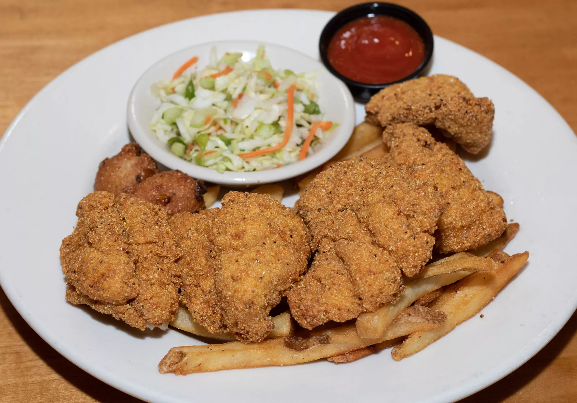 5 large pieces of U.S. farmed catfish hand breaded with seasoned cornmeal and deep fried. Served with crispy french fries, apple cider slaw, and our jalapeno hush puppies.