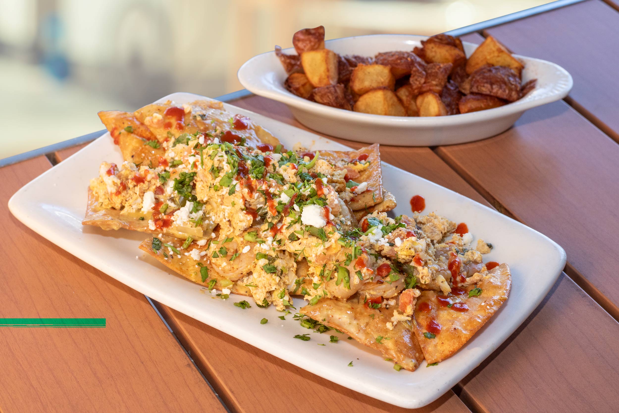 Fresh fried tortilla chips simmered in jalapeño cream sauce and topped with scrambled eggs, grilled shrimp, lump crab, pico de gallo, feta cheese, cilantro, and a sriracha drizzle. Served with breakfast potatoes.