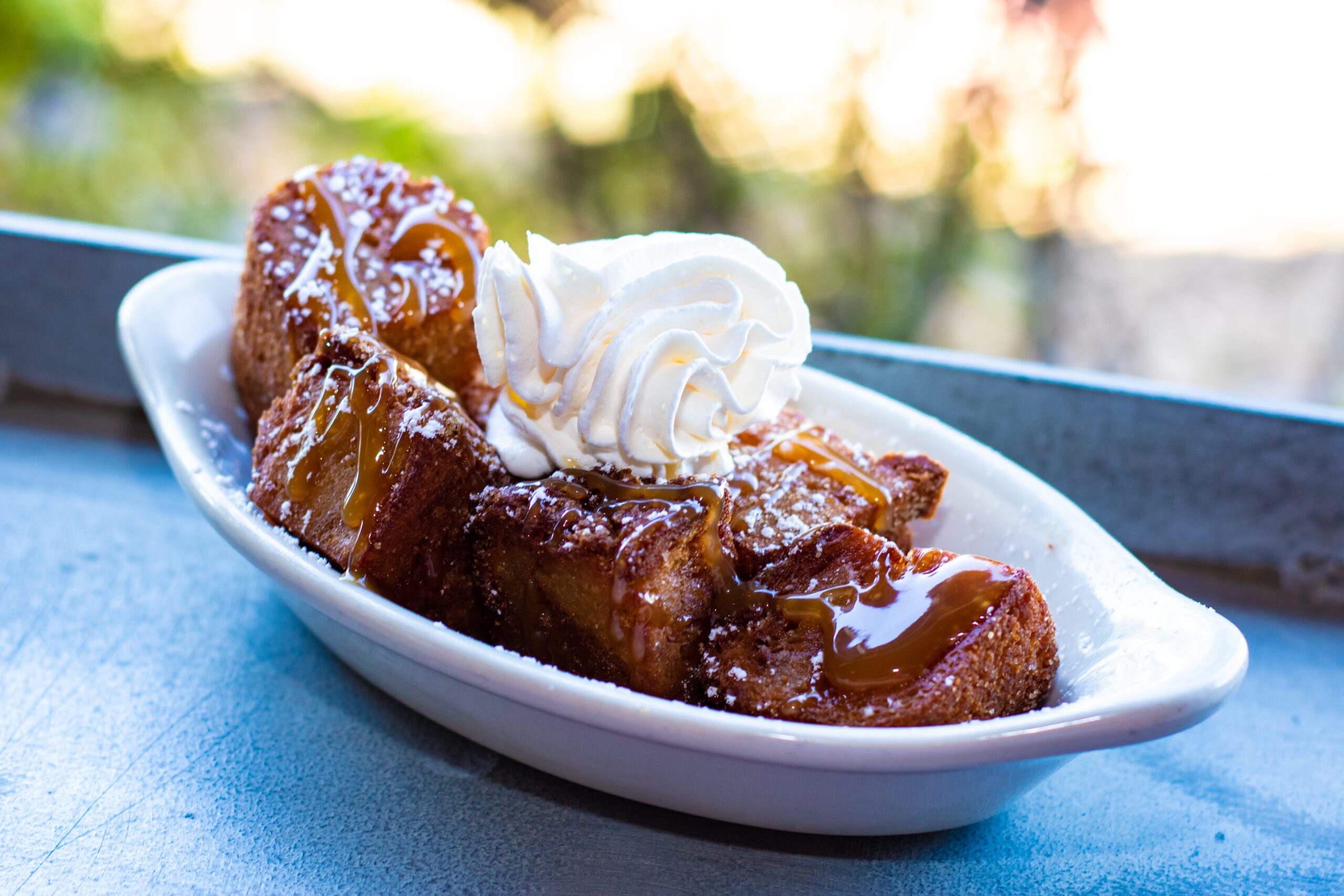 Bite-sized pieces of bread pudding deep fried with cinnamon sugar, caramel and whipped cream