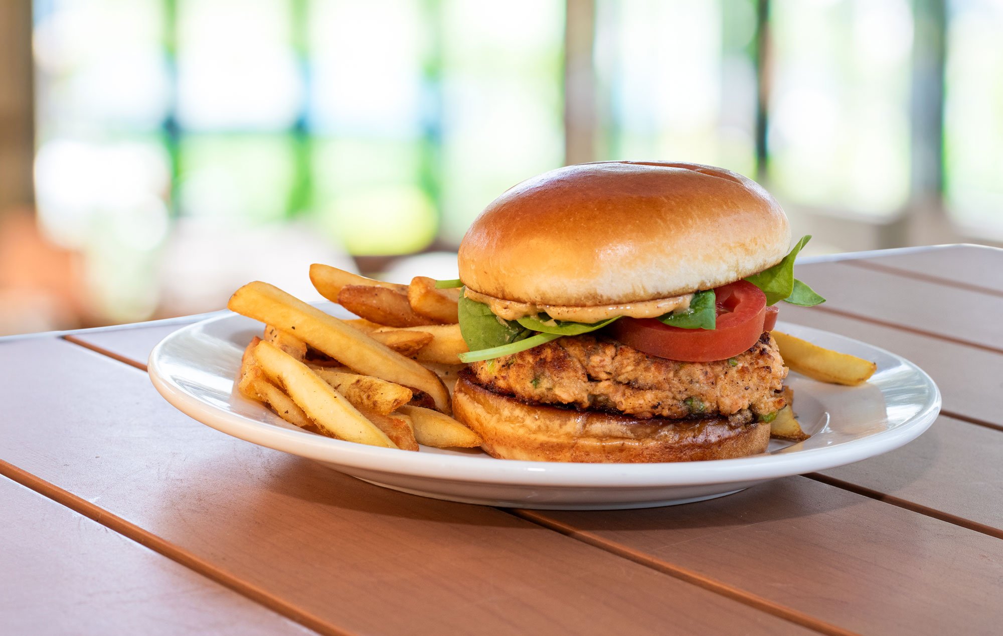 Fresh made Atlantic salmon patty, our homemade Old Bay aioli, spinach & tomato on a toasted brioche bun with crispy fries